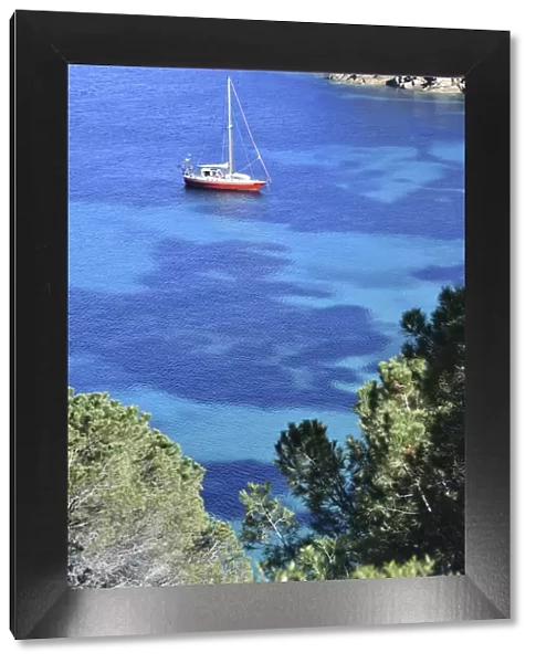 Sailboat in turquoise sea, cala delle Cannelle Giglio Island, Tuscany, Italy