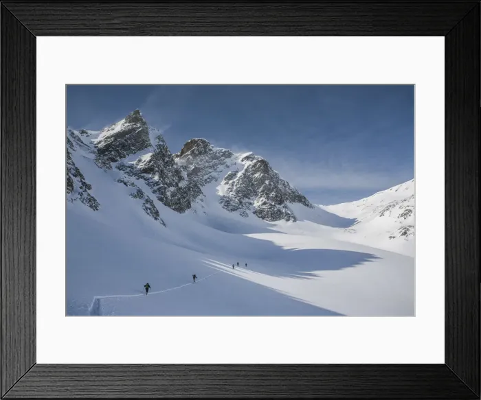 Framed Print : Ski mountaineers in Agnel valley, with the wind on the peaks. Engadina, Suisse