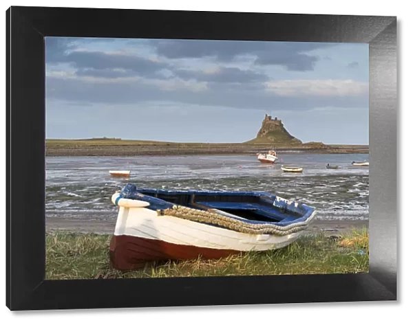 Fishing boat pulled onto the shore at Holy Island, looking towards the castle, Lindisfarne