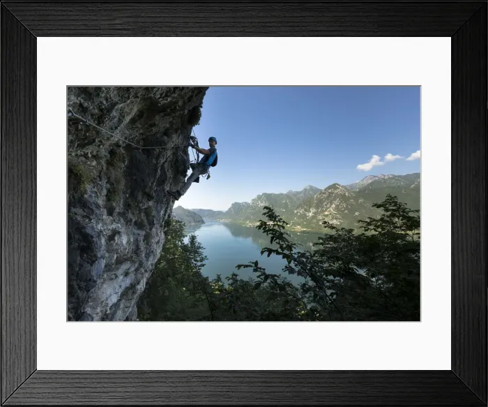 Framed Print : a hiker is climbing along the Ginestre klettersteig with the lake Idro in the background Framed Print : a hiker is climbing along the Ginestre klettersteig with the lake Idro in the background