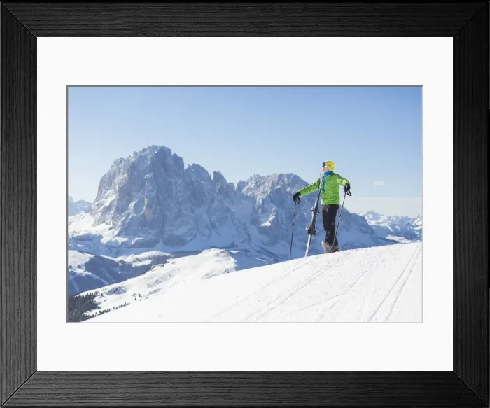 Framed Print : a skier is admiring the winter landscape in Val Gardena, with the Langkofel and Plattkofel