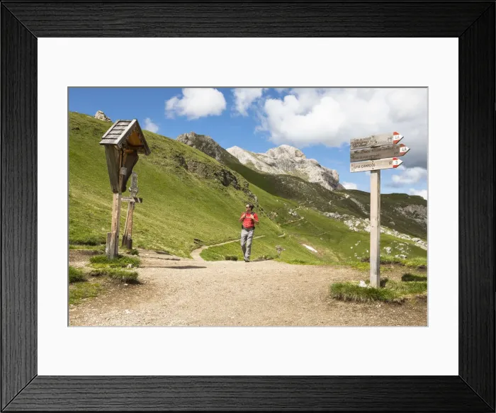 Framed Print : A hiker during a trekking at Kreuzkofeljoch in Gadertal with Peitlerkofelgruppe in Framed Print : A hiker during a trekking at Kreuzkofeljoch in Gadertal with Peitlerkofelgruppe in