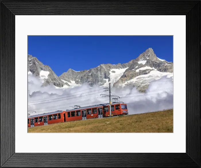 Framed Print : The Bahn train on its route with high peaks and mountain range in the background