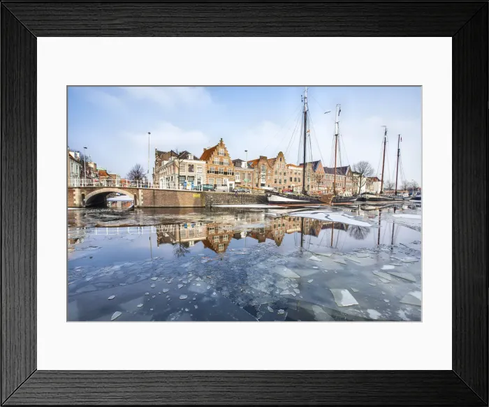 Framed Print : Buildings in Harleem reflecting in the half-frozen Spaarne River, Holland Framed Print : Buildings in Harleem reflecting in the half-frozen Spaarne River, Holland