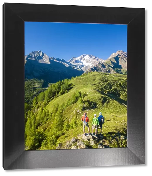 Hikers look towards Monte Disgrazia from Scermendone Alp, Sondrio province, Valtellina