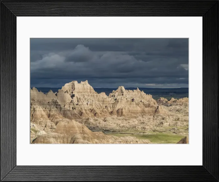 Framed Print : The eroded rocky formations of the Badlands region in South Dakota under a threatening