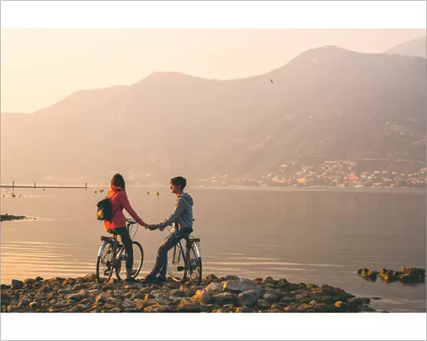 Pair of cyclists at sunset, iseo lake, Brescia province, Lombardy district, Italy