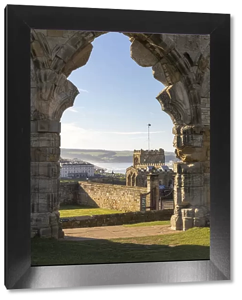 Ruined doorway of Whitby abbey frames the town, Whitby, North Yorkshire, England