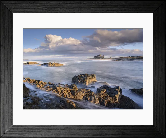 Framed Print : Looking across rocky ledges to Bamburgh Castle, Northumberland, England Framed Print : Looking across rocky ledges to Bamburgh Castle, Northumberland, England