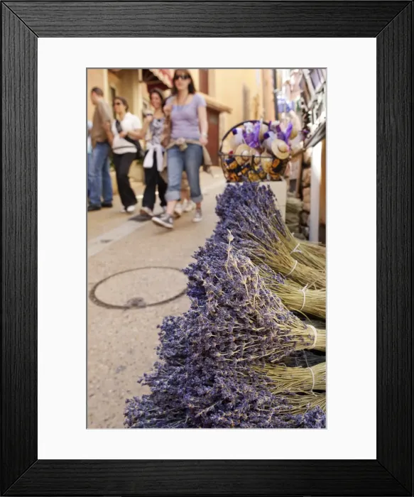 Framed Print : Rousillion; France. People walking down a street with lavender for sale in the foreground Framed Print : Rousillion; France. People walking down a street with lavender for sale in the foreground