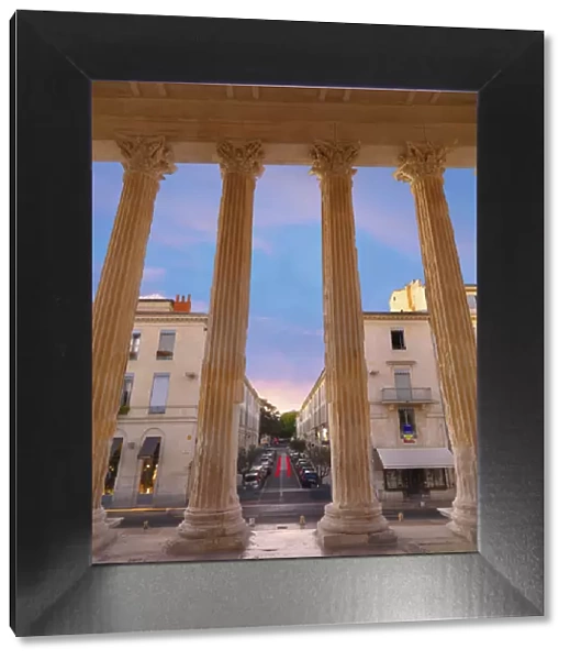 France, Provence, Nimes, Maison Caree, view through columns at dusk