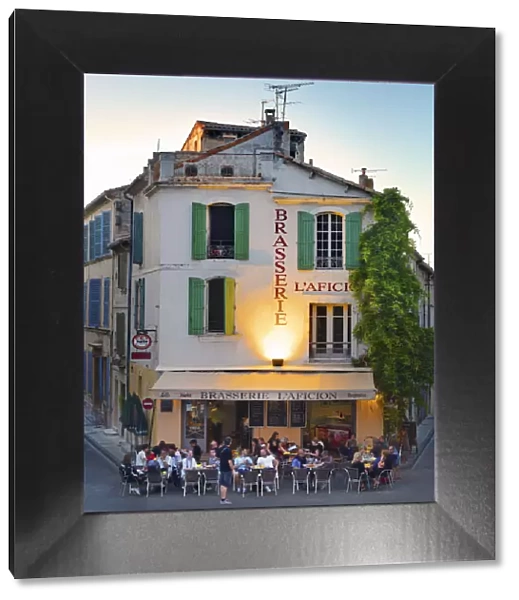 France, Provence, Arles, People at brasserie infront of Amphitheatre at dusk