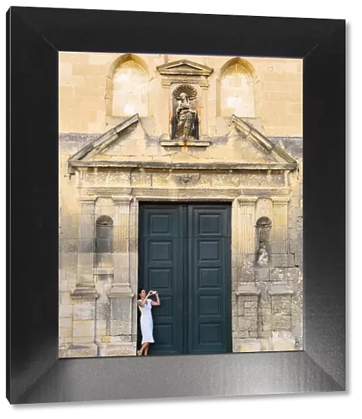 France, Provence, Arles, Notra Dame de la Major, Woman taking photograph in church