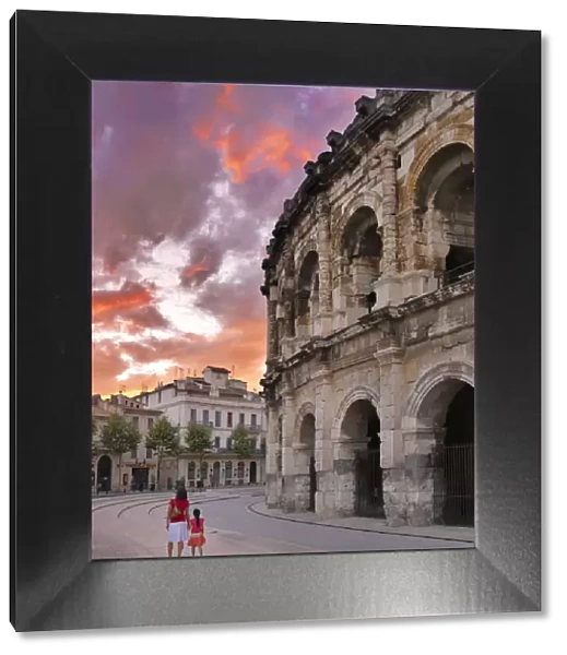 France, Provence, Nimes, Roman ampitheatre, Woman and girl walking past arena MR