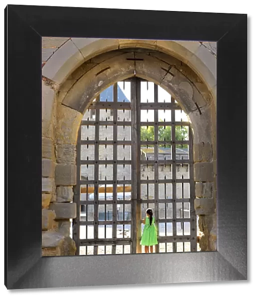 France, Languedoc, Carcassonne, Girl looking through castle gate (MR)