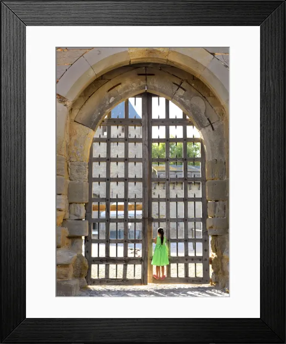 Framed Print : France, Languedoc, Carcassonne, Girl looking through castle gate (MR) Framed Print : France, Languedoc, Carcassonne, Girl looking through castle gate (MR)