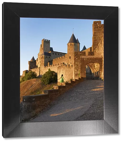 France, Languedoc, Carcassonne, girl walking on wall to Aude gate (MR)