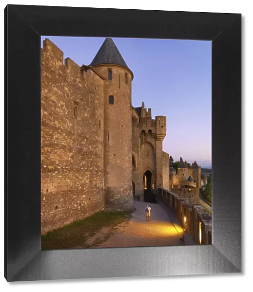 France, Languedoc, Carcassonne, man taking photograph from walls at dusk (MR)