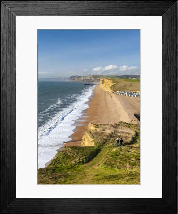 Framed Print : Two walkers enjoy the view along the beautiful vista from the cliffs of Burton Bradstock Framed Print : Two walkers enjoy the view along the beautiful vista from the cliffs of Burton Bradstock