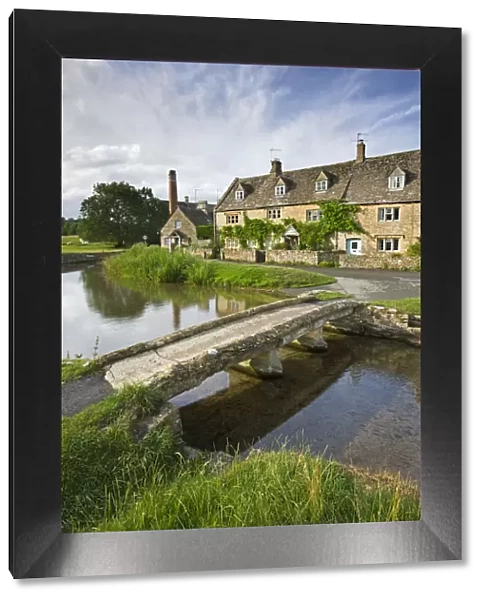 Stone footbridge and cottages at Lower Slaughter in the Cotswolds, Gloucestershire