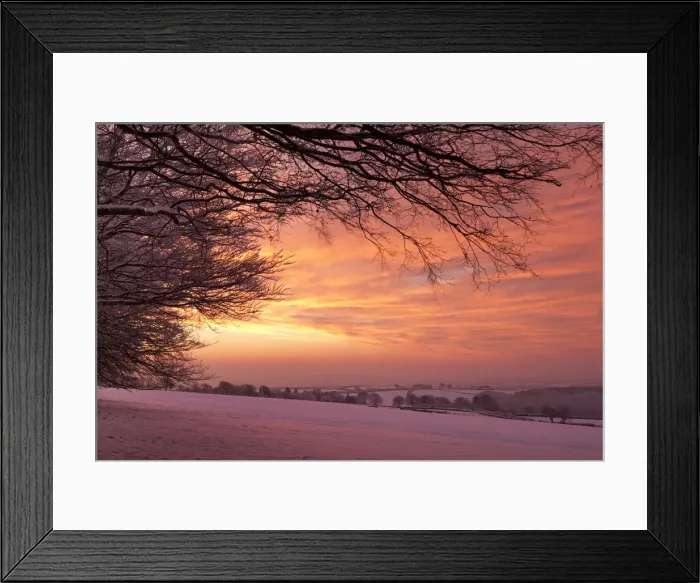 Framed Print : Spectacular dawn sky above snow covered countryside, Exmoor, Somerset, England. Winter