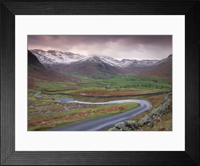 Framed Print : Small winding road leading into the Langdale Valley, surrounded by snow clad mountains Framed Print : Small winding road leading into the Langdale Valley, surrounded by snow clad mountains