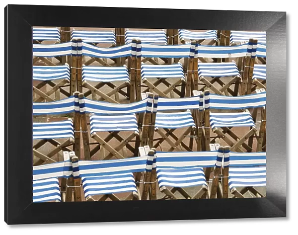 Rows of traditional blue and white deckchairs, Eastbourne, Sussex, UK