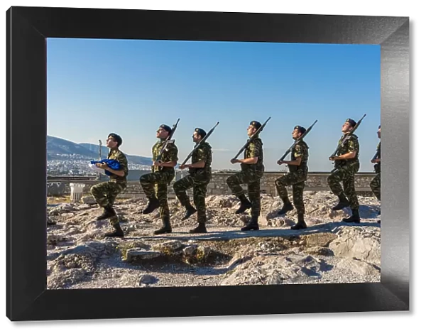 Greek army soldiers perform a ceremonial march on the Acropolis before raising the