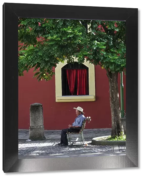 Elderly man sat in Plaza at Iglesia de la Merced, Comayagua, Central America, Honduras