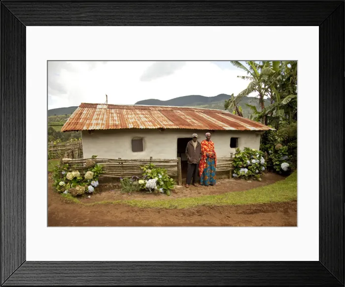 Framed Print : Burundi. A couple outside a traditional house on their farm Framed Print : Burundi. A couple outside a traditional house on their farm