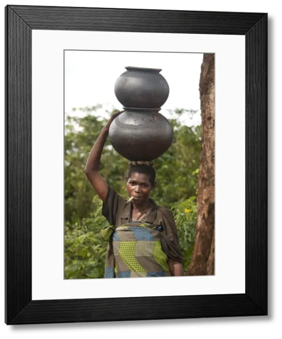 Framed Print : Burundi. A woman uses traditional pots to transport her goods to market Framed Print : Burundi. A woman uses traditional pots to transport her goods to market