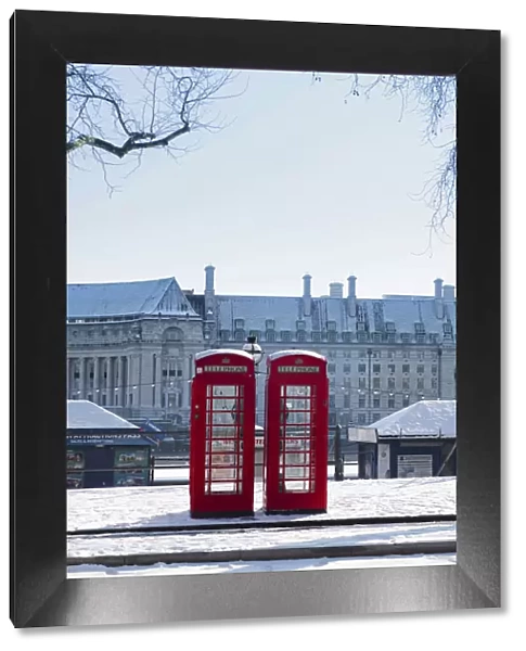 United Kingdom, England, London, red phone boxes on Victoria Embankment in the snow