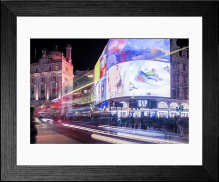 Framed Print : A night shot of light trails in front of the advertising hoardings in Piccadilly Circus Framed Print : A night shot of light trails in front of the advertising hoardings in Piccadilly Circus