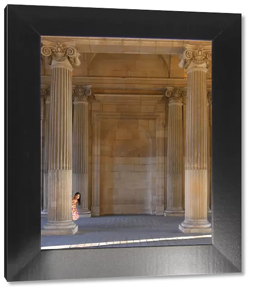 France, Paris, The Louvre, girl aged 8 hiding behind pillar (MR)