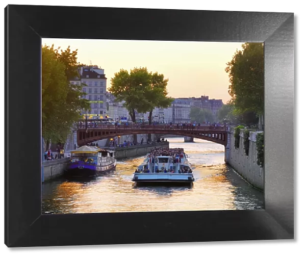 France, Paris, Tourboat on River Seine at sunset