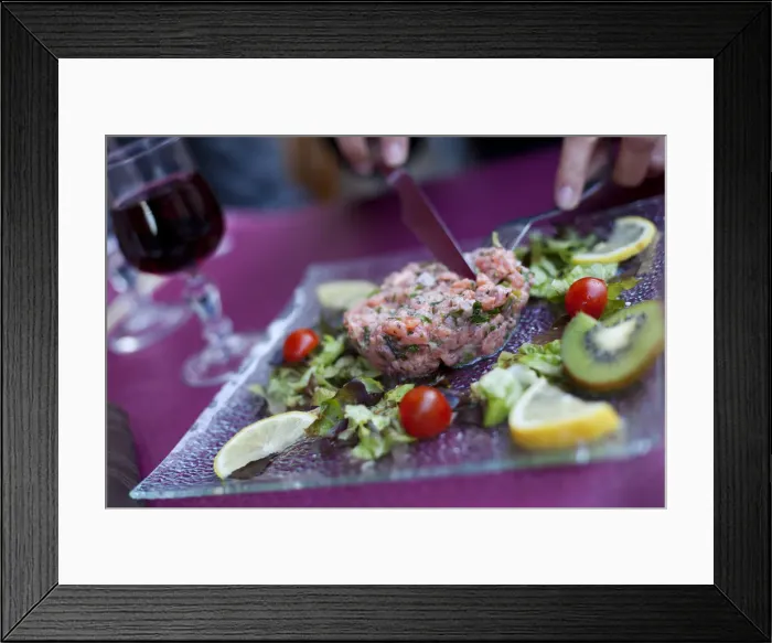 Framed Print : A diner cutting into steak tartare in a restaurant in paris France Framed Print : A diner cutting into steak tartare in a restaurant in paris France