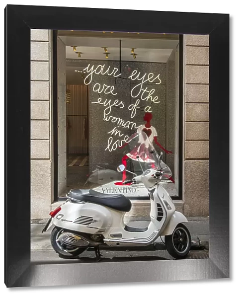 Italian Vespa scooter parked in Via Montenapoleone fashion street with Valentino shop