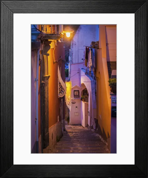 Framed Print : Procida island, Naples, Italy. A narrow street illuminated at dusk Framed Print : Procida island, Naples, Italy. A narrow street illuminated at dusk