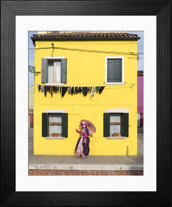 Framed Print : Woman in pink costume holding umbrella in front of yellow house during Carnival, Island Framed Print : Woman in pink costume holding umbrella in front of yellow house during Carnival, Island