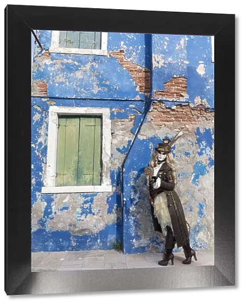 Woman in steampunk costume posing in front of old blue house, Burano Island, Venice