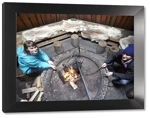 Europe, Finland, Lapland, Salla, tourists cooking over a wooden fire in a typical