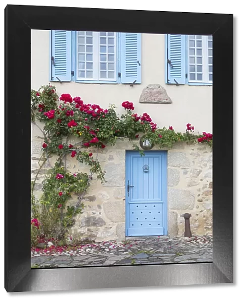 France, Correze, Argentat, A colourful facade of an old stone house with blue shutters