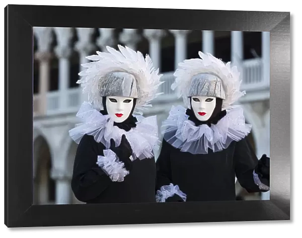 Two poseurs dressed as identical twins pose in St Marks Square during the Venice