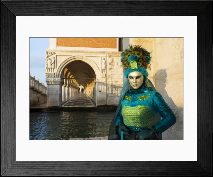 Framed Print : A woman in a mask and green costume stands by the canal next to St Marks square Framed Print : A woman in a mask and green costume stands by the canal next to St Marks square