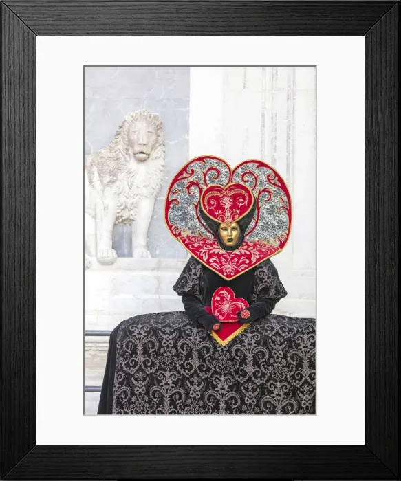 Framed Print : Heart-shaped costume stands in front of a sculpture of a lion at the Venice Carnival Framed Print : Heart-shaped costume stands in front of a sculpture of a lion at the Venice Carnival