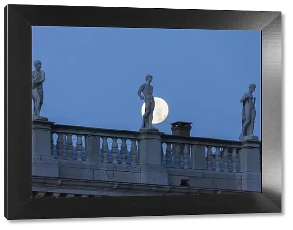 Statues of the Marciana librarys building in front of the full Moon, Venice, Veneto