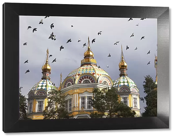 Pigeons flying over Zenkov Cathedral, Almaty, Kazakhstan