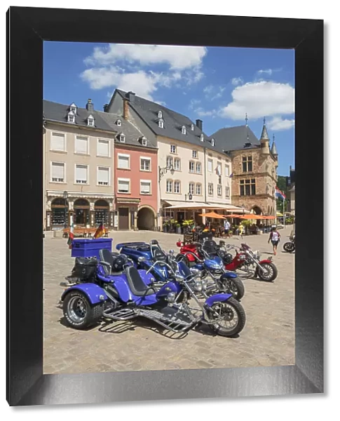 Three-wheeled motorbikes with the historic court house Denzelt at Echternach, Luxembourg