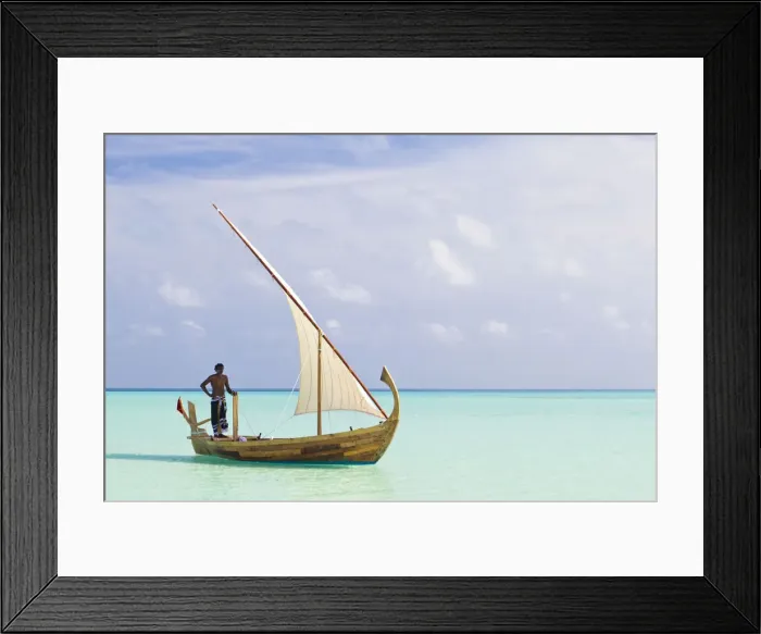 Framed Print : Maldives, Rasdhoo Atoll, Kuramathi Island. A Maldivian man sails a traditional Dhoni. MR Framed Print : Maldives, Rasdhoo Atoll, Kuramathi Island. A Maldivian man sails a traditional Dhoni. MR