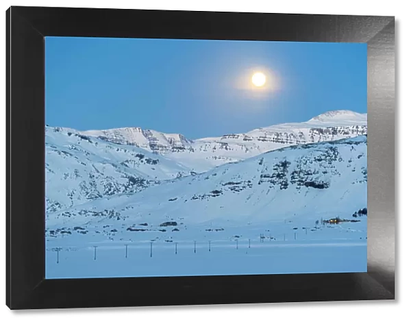 Iceland, Europe. Lonely house on the mountains in a winter landscape with full moon